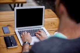 image shows man working on a laptop